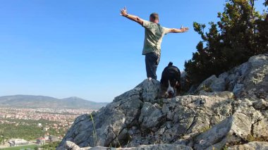 Bir Entlebucher Dağ Köpeği ve sahibi çevredeki vahşi hayatı takdir etmek için yüksek bir uçuruma tırmandı..