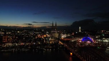 Almanya 'nın güzel şehri Köln' ün hava klibi. Gece günbatımından hemen sonra. İnsansız hava aracı geliyor. Videoda ünlü katedral Dom, Rhein nehri, Hohenzollernbrcke köprüsü ve güzel yıldırımlarla dolu eski şehrin geri kalanı gösteriliyor..