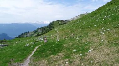 Alplerde koşan spor elbiseli genç bir kadının uçuş videosu. Avusturya 'da yaz mevsiminde güzel dağlar, Hhenweg