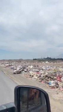Peru 'daki yollar boyunca uzanan inanılmaz miktardaki çöpü sürüp belgelemek için arabadan görüntüleri alan bir kadın. Çöp sorunu, çevre değerlendirmesi