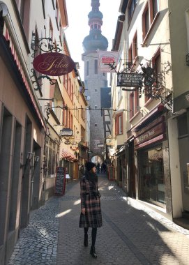 Zarif kış kıyafetleri içindeki kadın tarihi Cochem sokaklarında yürüyor. Moselle Nehri Vadisi, Rhineland, Almanya yakınlarındaki eski bir şehir.