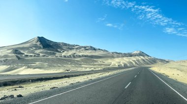 Pan Amerikan Karayolu, Peru. Uçsuz bucaksız bir çölün ortasında mükemmel asfalt bir otoyol. Dağlar ve kumullarla çevrili eşsiz ve görkemli bir çevre yaratıyor.. 