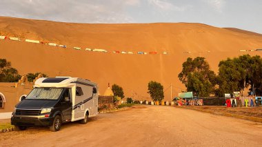 Sahilde Peru 'da dururken modern bir karavan. Pan-Amerikan otoyolu çöl ve kum tepelerinden geçiyor..