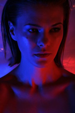 Renkli mavi ışıklı model kadın, zarif makyajı ve saçı olan güzel bir kadının portresi. Sanat tasarımı vesikalığı