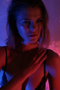 Renkli mavi ışıklı model kadın, zarif makyajlı ve parlak tenine dokunan sütyenli güzel bir kadının portresi. Sanat tasarımı vesikalığı