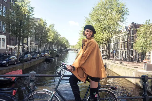 Amsterdam caddesinde bisiklet süren güzel zarif bir kadın - Avrupa 'da yaz tatilinin tadını çıkaran mutlu kadın turist - Tatiller, seyahat ve ulaşım yaşam tarzı konsepti