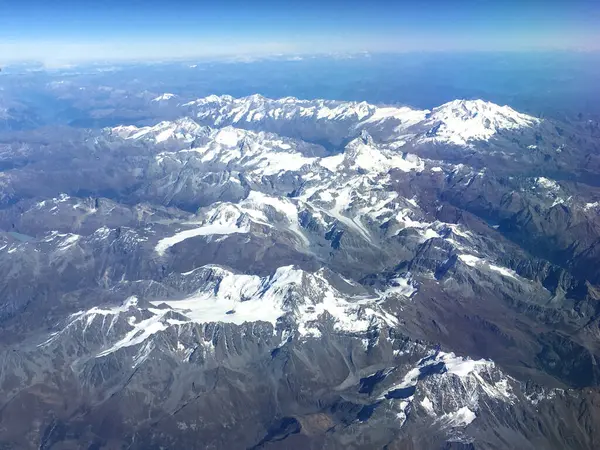 İtalya ve Avusturya arasında yaz mevsiminde Avrupa Alpleri üzerinde uçan uçaktan yapılan hava manzarası. Dağların tepesinde karla kaplı, dünyayı gören herkes..