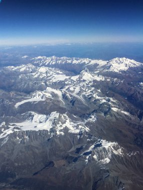 İtalya ve Avusturya arasında yaz mevsiminde Avrupa Alpleri üzerinde uçan uçaktan yapılan hava manzarası. Dağların tepesinde karla kaplı. 