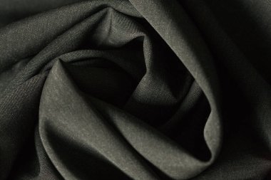 Siyah tonlu, yeni, saf yün kumaş. Ticari ve zarif kıyafetler yapmak için Almanya 'da yapılmış. İnce tekstil malzemelerinin dokusunu kapat. Soyut arkaplan duvar kağıdı. Bükülmüş kumaş. Eğilim
