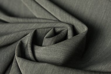 Gri tonlu, yeni, saf yün kumaş. Almanya 'da iş yapmak için yapılmış. Zarif ve şık kıyafetler. İnce tekstil malzemelerinin dokusunu kapat. Soyut arkaplan duvar kağıdı. Bükülmüş kumaş.. 