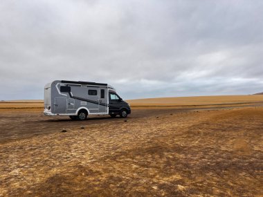Peru 'nun Pisco Eyaleti' ndeki Ulusal Park Reserve Paracas 'ta muhteşem çöl manzarası dururken modern karavan evi. Kervan kızıl kumlu plajları, vahşi yaşamı ve milli parkın doğasını keşfediyor..
