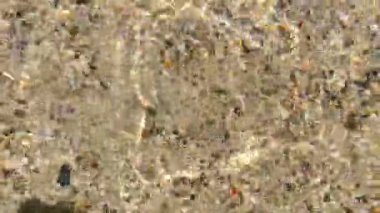 Yakın çekim, temiz deniz suyu akıyor. Güzel, berrak okyanus suyu, gölet, deniz kumda hareket ediyor.. 
