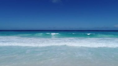 Seyşeller Adası La Dique, Coco Sahili 'nde turkuaz su dalgaları üzerinde yüzen insansız hava aracı video görüntüleri.. 