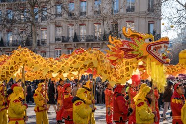 Paris, Fransa-02.02.2025 Neşeli kalabalık Şanzelize boyunca etkileyici bir ejderha dansına liderlik ederek Çin 'in yeni yılını parlak kostümler ve kahkahalarla kutluyor..