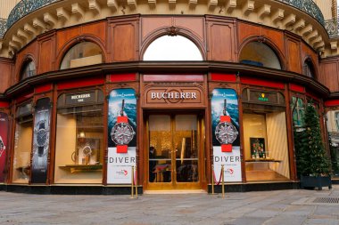 Paris, Fransa-2024-11-20 Lüks bir saat mağazasında gösterişli gösteriler ve büyük pankartlar sergileniyor. Butik, karmaşık bir mimari sergiliyor ve canlı bir şehirde göze çarpıyor.