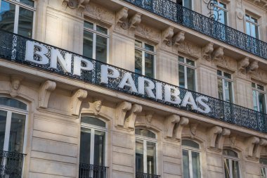 Paris. 02.02.2025 Ziyaretçiler Paris 'teki güzel detaylı binaya hayran kalmışlar, cephesi sanatsal demir işçiliği ve zarif harflerle süslenmiş, güneş ışığının yumuşak parıltısıyla güneşlenmiş..