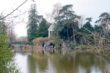 Kubbe ve yapay mağara, Daumesnil Gölü 'nün yanındaki Ile de Reuilly' de ağaçlarla çevrilidir. Bu durum, sakin bir öğleden sonra Bois de Vincennes 'in sakinliğini yansıtır..
