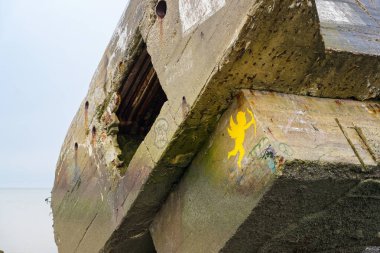 Büyük bir beton yapı, grafiti sanatının görülebildiği havalanma belirtileri gösteriyor. Etrafı sakin, alacakaranlık ışığı manzarayı aydınlatıyor..