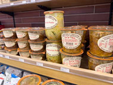 Paris, Fransa... 15.12.2024 çeşitli reçel kavanozları, rahat bir zanaatkar dükkanındaki ahşap raflarda güzelce düzenlenir. Her kavanozda renkli etiketler ve çeşitli ev yapımı malzemeler var..