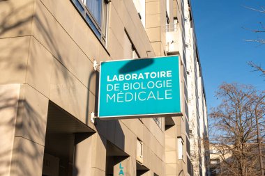Paris, Fransa-14.01.2025 Tıp Biyolojisi labaratuvarının adını gösteren parlak mavi bir tabela açık bir günde modern bir binanın dış kısmında asılı duruyor..