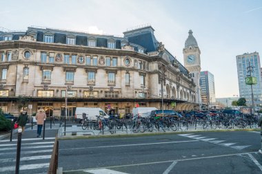Paris, Fransa-14.01.2025 Büyük tarihi tren istasyonu karmaşık bir mimari ve saat kulesine sahiptir. Bisikletler ön tarafta park edilmiş, yaya geçidinde yürüyen yayalar var..