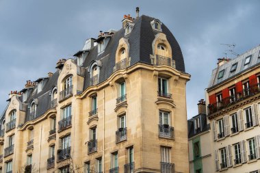 Paris 'in göbeğindeki bulutlu gökyüzüne karşı büyüleyici tarihi binalar yükseliyor. Mimari tasarım, dekoratif balkonlar ve eşsiz çatı şekilleri de dahil olmak üzere karmaşık ayrıntıları sergiliyor. Sıcak melodiler.