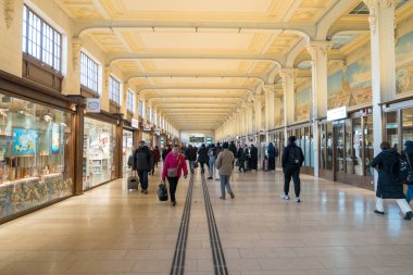 Paris, Fransa-14.01.2025 Kalabalık zarif mimarisi ve canlı dekorasyonları olan güzel tasarlanmış bir atari salonunda geziniyor. Öğlen oldu..