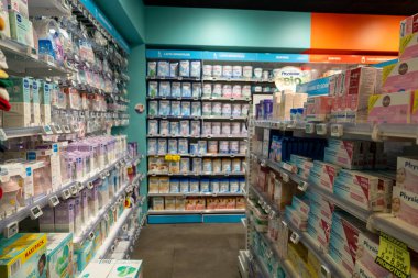 13 Ocak 2025 'te Paris' te bulunan parlak ışıklı eczane raflarda düzenli olarak düzenlenmiş çeşitli sağlık ürünleri sergiliyor. Koridorlar tezgahın üstünden geçen eşyalarla dolu.