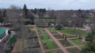 Havadan bakıldığında güzel dizayn edilmiş bir bahçe, düzgün dizayn edilmiş yollar ve dikim yatakları sergileniyor. Yeşillik yapraksız ağaçların arka planına karşı duruyor, tipik bir kış mevsimi. Yakınlarda.