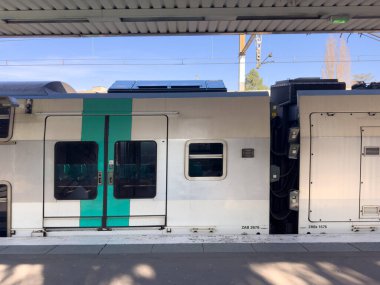 Chatou, Fransa-16.02.2025 Platformda parlak, modern bir tren duruyor, sakin bir atmosferle öğleden sonra güneşini yansıtıyor, banliyö yolcuları yolculukları için hazırlanıyor..