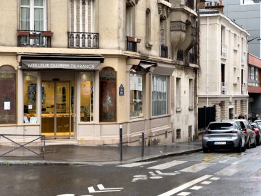 Paris, Fransa-25.02.2025 Paris 'in hareketli bir sokağının köşesinde sıcak ışıkları yağmurlu ortamda parlıyor, müşterileri lezzetli hamur işlerinin tadına varmaya davet ediyor..