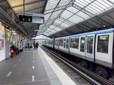 Paris, Fransa-25.02.2025 yolcuları, doğal ışık ve modern mimari ile dolu canlı bir şehir istasyonuna bir metro treninin geleceğini umarak platformda toplandılar..