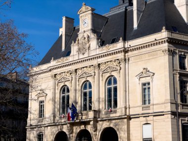 Paris, Fransa-23.02.2025. Karmaşık tasarımlı zarif bir Paris binasının çarpıcı manzarası, tarihi mimarinin güzelliğini gözler önüne seren parlak mavi gökyüzüne karşı gururla duruyor..