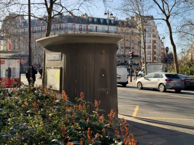 Paris, Fransa-23.02.2025 İnsanlar hayat dolu cadde boyunca yürürken çiçekler ve zarif mimariyle çerçevelenmiş arabalar, ilkbaharda şehir hayatının özünü yakalıyorlar..