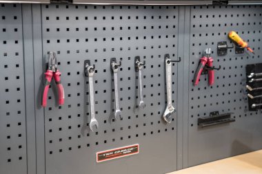 Paris, Fransa-09.02.2025 Çeşitli el aletleri gri tahta üzerinde mükemmel bir şekilde asılı, herhangi bir DIY meraklısı veya tamirci için organize ve verimli bir çalışma alanı oluşturur.