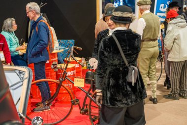 Paris, Fransa-09.02.2025 Ziyaretçiler klasik bisikletlere hayranlık duyarken, antika moda ve nostaljik hatıralar sergileyen bir retro pazar etkinliğinde canlı sohbetler yapıyorlar..