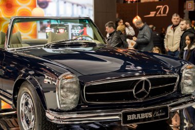Paris, Fransa-09.02.2025 Klasik bir üstü açık araba sergisi seyircilerini cezbediyor, coşkulu araba tutkunları tarafından çevrelenmiş iken büyüleyici cazibe ve nostalji..