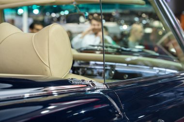 Paris, Fransa-09.02.2025 Çekici bir üstü açık araba tasarımı ve işçiliği vurguluyor, hayranları ve gezginleri gece canlı bir şehir otomobil fuarına çekiyor.