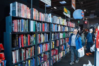 Paris, Fransa-09.02.2025 Ziyaretçiler canlı bir kitap fuarına katılıyor, raflardaki kitaplar arasında geziniyor, canlı atmosferi ve çeşitli edebiyat eserlerini emiyor..