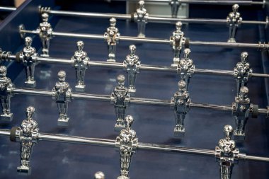 Paris, Fransa-09.02.2025 Dostlar heyecanlı bir langırt maçına girişirken, Masanın canlı mavi arka planına karşı parlak metal oyuncularına odaklanırlar.