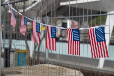 Paris, Fransa-09.02.2025 Küçük Amerikan bayrakları bir çit boyunca asılı duruyor ve neşeli bir kutlama sırasında aile ve arkadaşlar bulutların altında toplanırken neşeli bir dokunuş ekliyor..