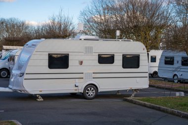 Varennes-sur-SeineFrance-23.02.2025 A classic camper van is parked in a peaceful RV park, surrounded by trees, showcasing a perfect backdrop for a weekend getaway or adventure. clipart