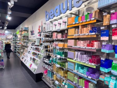 Paris, Fransa-25.02.2025 Müşteriler cilt bakım ürünleri ve makyaj ürünleriyle dolu canlı bir güzellik koridorunu keşfediyorlar. Renkli ambalaj mağazada davetkar bir atmosfer yaratıyor.