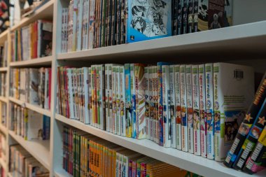 Paris, Fransa-23.11.2024 parlak renkli manga ciltleri raflara dizilerek büyüleyici bir kitapçıda sıcak ve misafirperver bir atmosfer yaratıyor. Okuyucular içlerindeki büyüleyici hikayelere çekilirler..