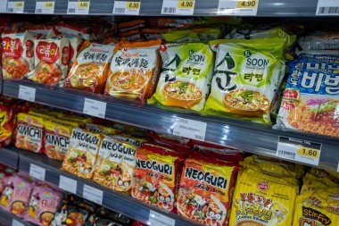 Paris,France-23.11.2024 Rows of instant ramen packages line the shelves of a lively Asian market, showcasing diverse flavors and culinary traditions, enticing shoppers on a bustling afternoon. clipart