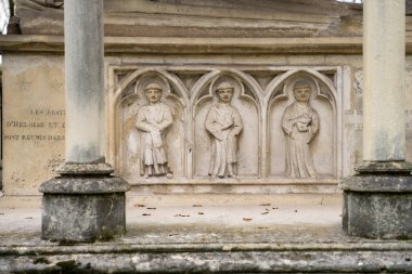 Paris,France-23.11.2024 Detailed stone reliefs of four historical figures are nestled within arched niches, showcasing artistry that reflects a bygone era amidst a serene outdoor environment. clipart