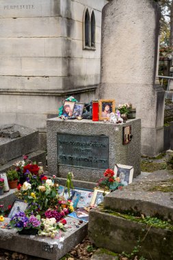 Paris, Fransa-23.11.2024 Renkli çiçekler ve kişisel hatıralar dingin bir mezarlıkta bir mezar süslüyor, güzel bir sonbahar günü sevdiklerinin ve kaybettiklerinin kalpten anılarını yakalıyor..