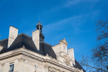 Çarpıcı tarihi mimari, canlı mavi gökyüzüne karşı yükselir. Zarif taş işçiliği ve güzel bir saat kulesiyle Paris 'in zarafetini yakalar..