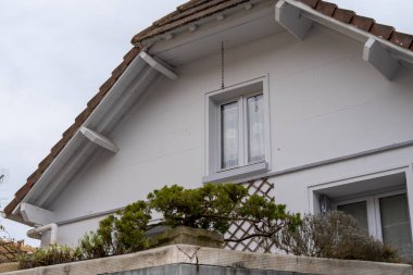 La Roche-Guyon 'daki tuhaf beyaz bir ev, bulutlu bir gökyüzünün altında karmaşık detayları ve sakin atmosferiyle Fransız mimarisinin özünü yakalıyor..