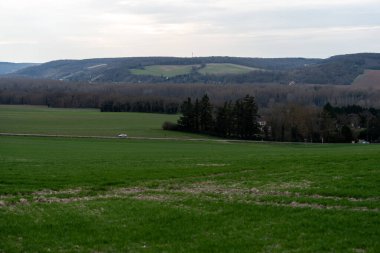 Uçsuz bucaksız yeşil tarlalar kayan tepelere doğru uzanıyor, La Roche-Guyon 'da sakin bir manzara resmediyor, doğanın ilkbaharın erken saatlerinde hafif bir ışıkla uyandığı yer..